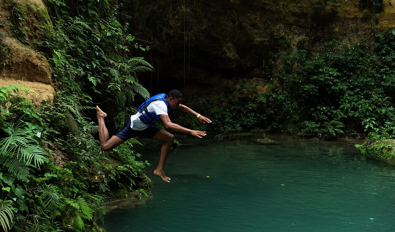 A swimmer jumping into the Blue Hole at Island Gully Falls near Ocho Rios